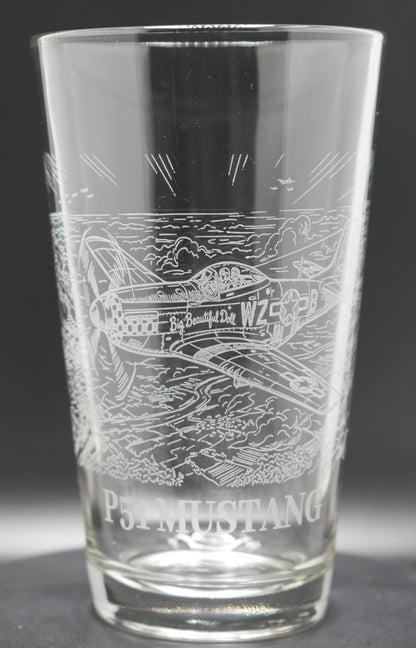 A clear glass pint glass featuring an engraved P-51 Mustang airplane 